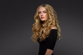 blonde-woman-with-long-curly-hair-over-dark-backgr-2021-08-28-17-42-46-utc.jpg